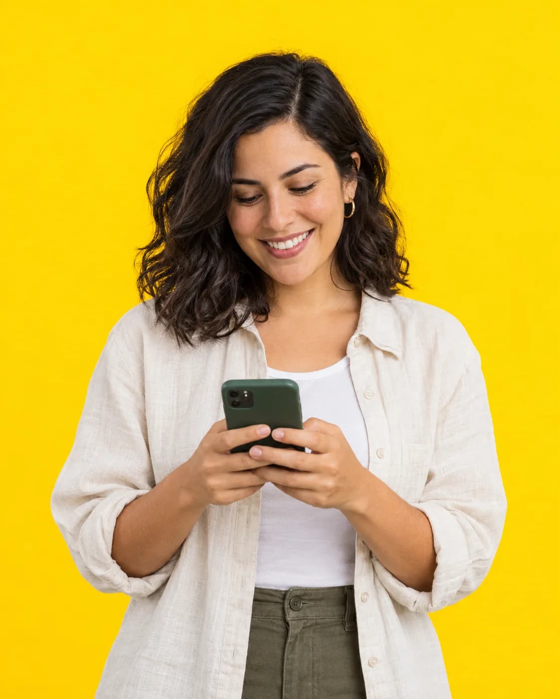 Una emprendedora sonríe mientras usa su celular.